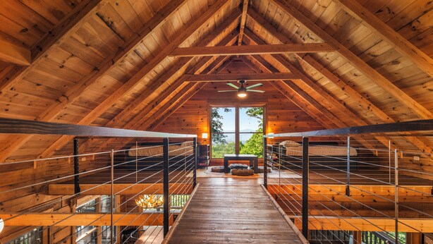 A wooden interior with a high ceiling, a central staircase, and a view through large windows. - The Maple Bear - Amazing Mountain Views + Hot Tub (Blue Ridge)