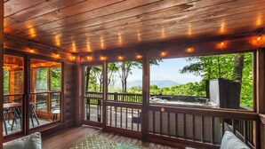 A wooden deck with a hot tub, outdoor seating, and a view of the mountains. - The Maple Bear - Amazing Mountain Views + Hot Tub (Blue Ridge)