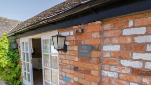 A brick building with a sign reading "THE DAIRY" and a door leading inside. - The Dairy (Nuneaton)