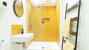 A bathroom with a shower, a sink, and a mirror.