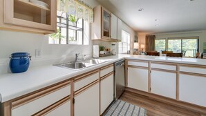 A modern kitchen with white cabinetry, a stainless steel sink, and a built-in dishwasher. - Branson Condo Near 76 Strip & Silver Dollar City (Branson)