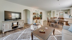 A living room with a TV, sofa, coffee table, and dining area with chairs and a table. - Branson Condo Near 76 Strip & Silver Dollar City (Branson)