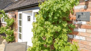 Un bâtiment en briques avec une enseigne indiquant « THE NEST » et une porte dotée d’une fenêtre.