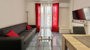 A modern living room with a sofa, a coffee table, and a TV mounted on the wall. - Luminous cocoon near the beach (Saint-Raphaël)