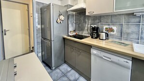 A modern kitchen with a stainless steel refrigerator, a dishwasher, and a coffee maker on the countertop. - Luminous cocoon near the beach (Saint-Raphaël)