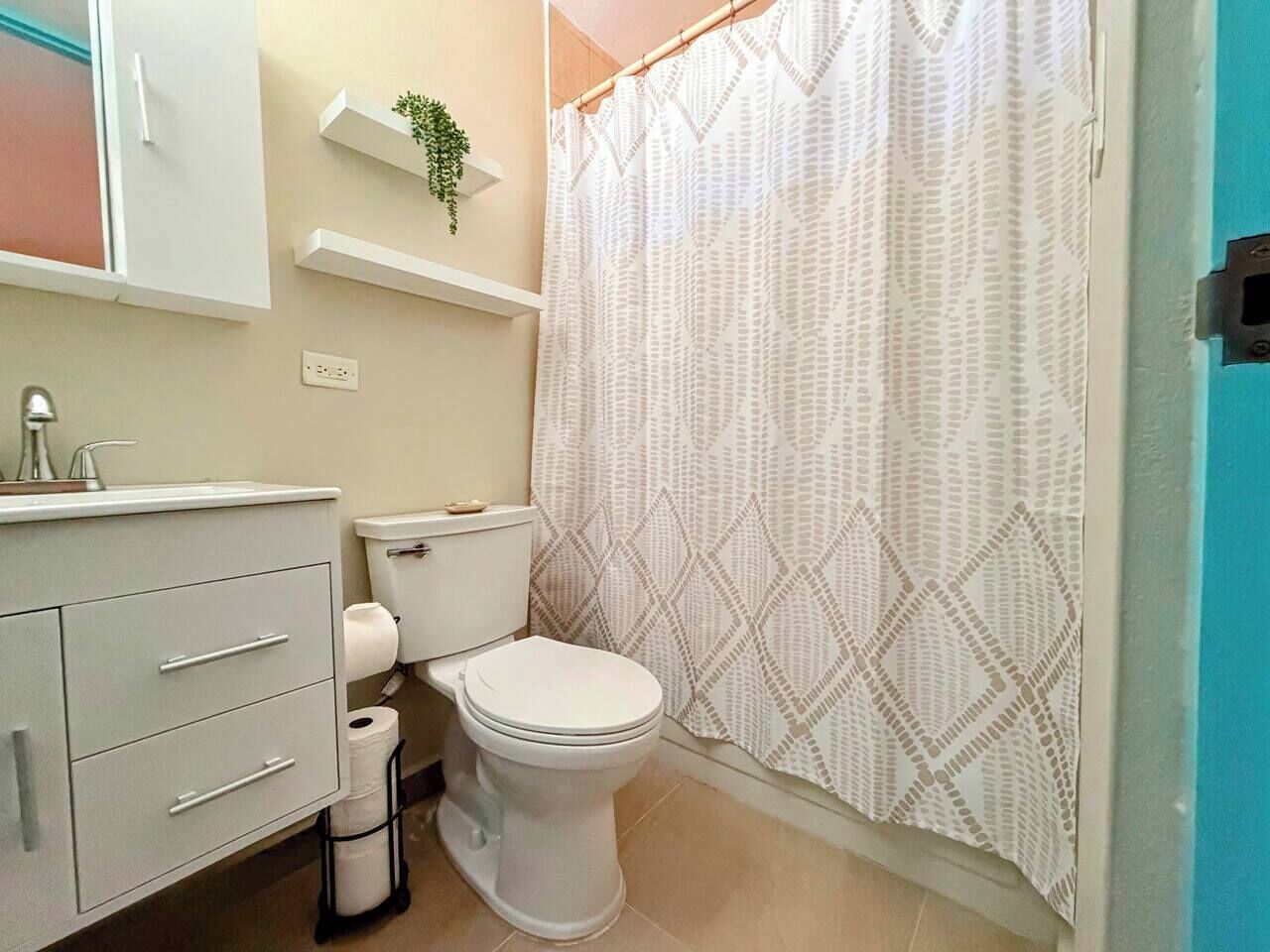 A bathroom with a toilet, sink, and a shower curtain.