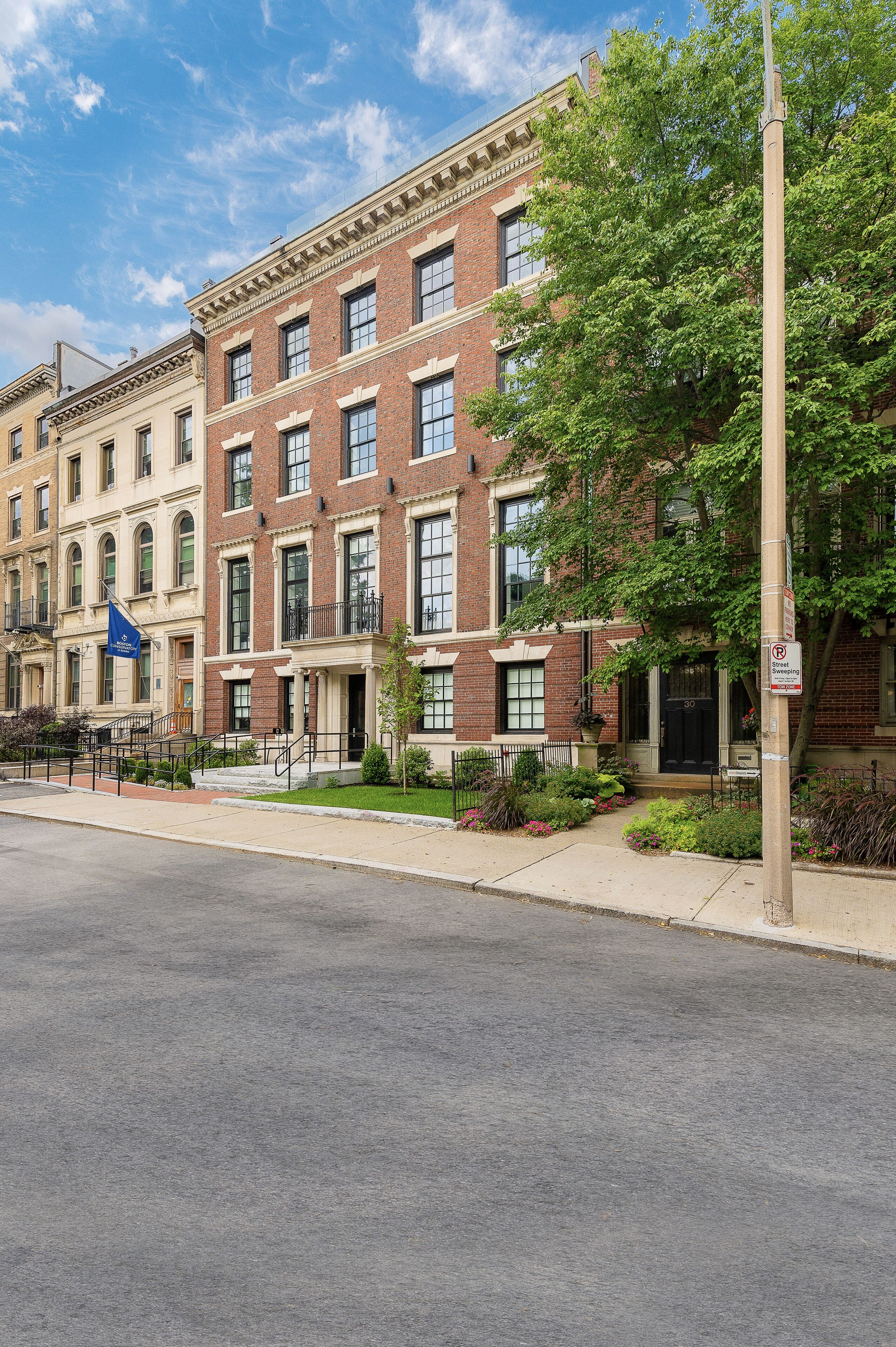 A row of brick townhouses with a clear sky.
