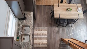 A modern kitchen with a wooden dining table, a built-in sink, and a kitchen island. - Cozy, Spacious, and Right on the Banks of Rocky Creek, Two Creeks Crossing Resort (Livingston)