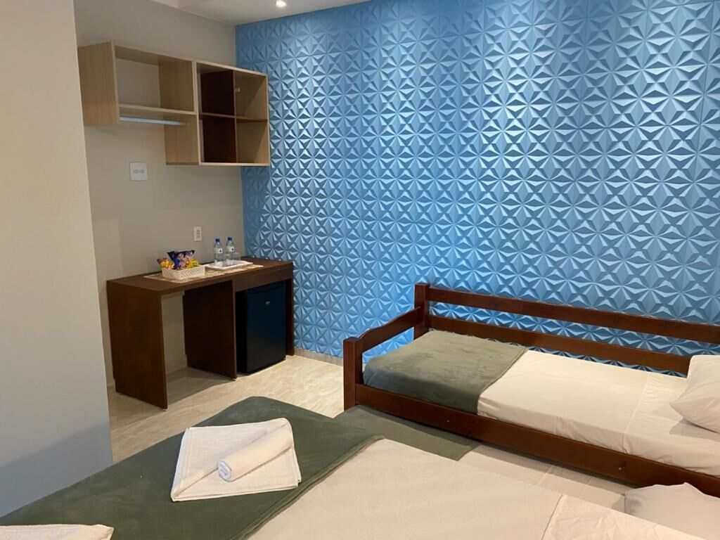 Een hotelkamer met een bed, een bureau en een muur met een geometrisch patroon.