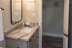 A bathroom with a marble sink, a mirror, and two informational posters on the wall. - The Perfect Retreat from you Cares and Worries, Two Creeks Crossing Resort (Livingston)