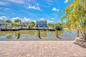 A waterfront property with a dock, a pool, and a building with a dome.