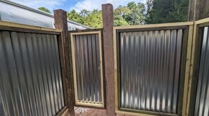 A corrugated metal fence with wooden posts.