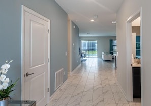 Stunning hallway leading to a spacious living area with a large window offering a view of the outdoors.