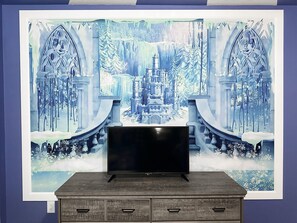 Enjoy a cozy evening in with a flat-screen TV and a beautiful winter scene artwork.