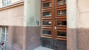 A building entrance with a double wooden door, a small step leading up to it, and a bicycle parked outside. - 2ndhomes Modern Studio close to the Sea (Helsinki)