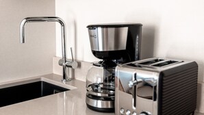 A kitchen with a modern stainless steel toaster, a coffee maker, and a sink. - 2ndhomes Modern Studio close to the Sea (Helsinki)