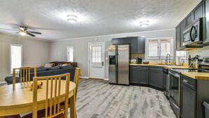 A modern kitchen with a dining area, stainless steel appliances, and a ceiling fan. - Cozy Mtn. Getaway in South Asheville (Asheville)
