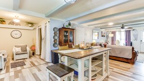 A spacious living area with a wooden dining table, a sofa, and a bed. There is a kitchen area with a refrigerator and a microwave. - Charming St James Home Near Maramec Spring Park! (St James)