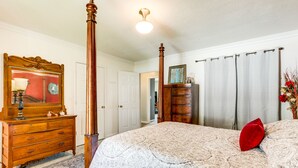 A bedroom with a four-poster bed, a wooden dresser, a mirror, and a door leading to another room. - Charming St James Home Near Maramec Spring Park! (St James)