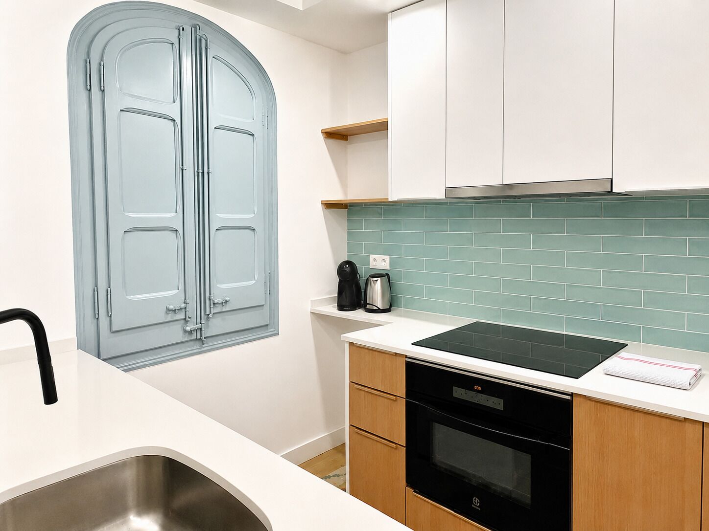 A kitchen with a double door, a sink, a stove, and a countertop.