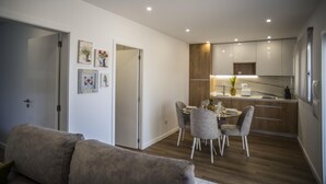 Eine moderne Küche mit Holzausstattung, einem Esstisch mit vier Stühlen und einem Kühlschrank.