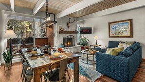 Ein modernes Wohnzimmer mit Kamin, Essbereich und einer gemütlichen Sitzecke.