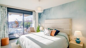 A bedroom with a large bed, a nightstand, a lamp, a chair, and a view of the outdoors through a sliding door. - Exclusive, quiet urbanization Oasis 325 (AN)