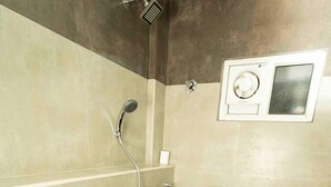 A bathroom with a shower, toilet, and hand dryer. - ADDRESS7 Hotel Kalamassery (Kanayannur)