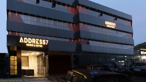 A modern building with a sign for 'ADDRESS7' indicating rooms and suites. - ADDRESS7 Hotel Kalamassery (Kanayannur)