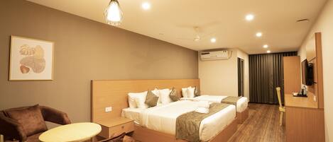 A hotel room with a large bed, a desk, a chair, and a ceiling fan.