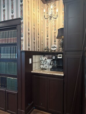 A bar area with a coffee machine, a tea set, and a sign that says 'Our Little Coffee Bar.'