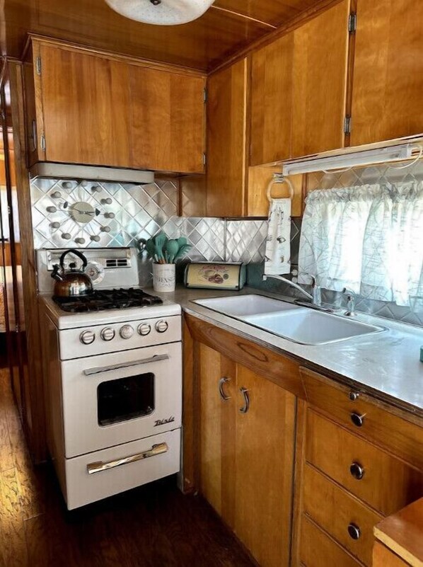 Electric stove and fully equipped kitchen.