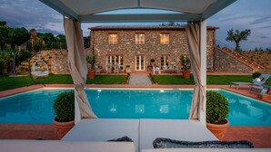 A stone house with a swimming pool, outdoor seating, and a covered patio area. - Villa Flora in Montecarlo (Montecarlo)