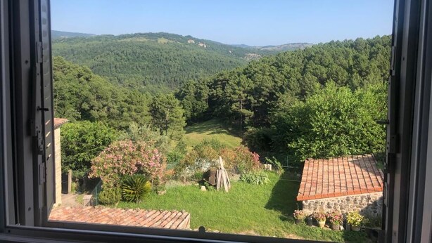 A view from a window overlooking a lush green valley with terraced roofs and a clear sky. - Maison de Village Située Dans un Hameau Très Calme , Agréable à Vivre (saint julien du serre)