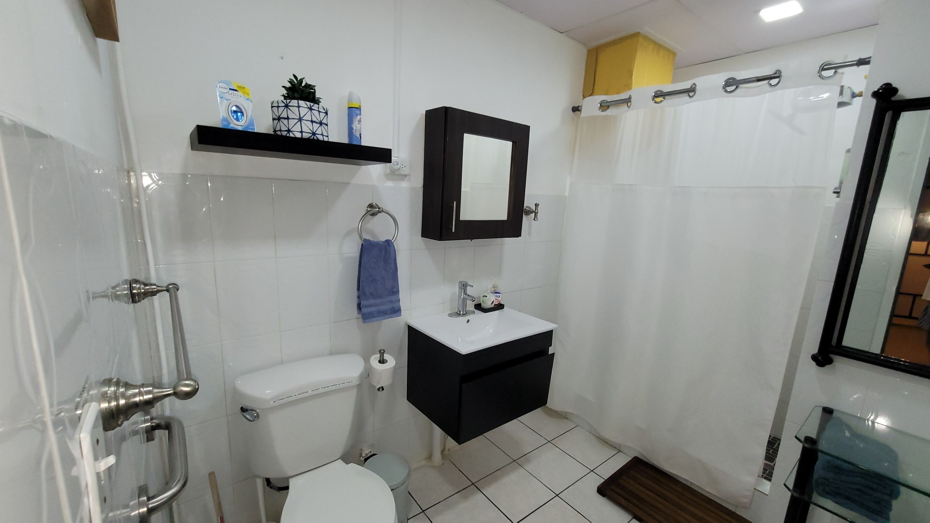 Un baño pequeño con inodoro, lavamanos y zona de ducha.