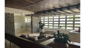 Un intérieur moderne avec un coin salon, une plante en pot et une vue à travers une fenêtre à carreaux.