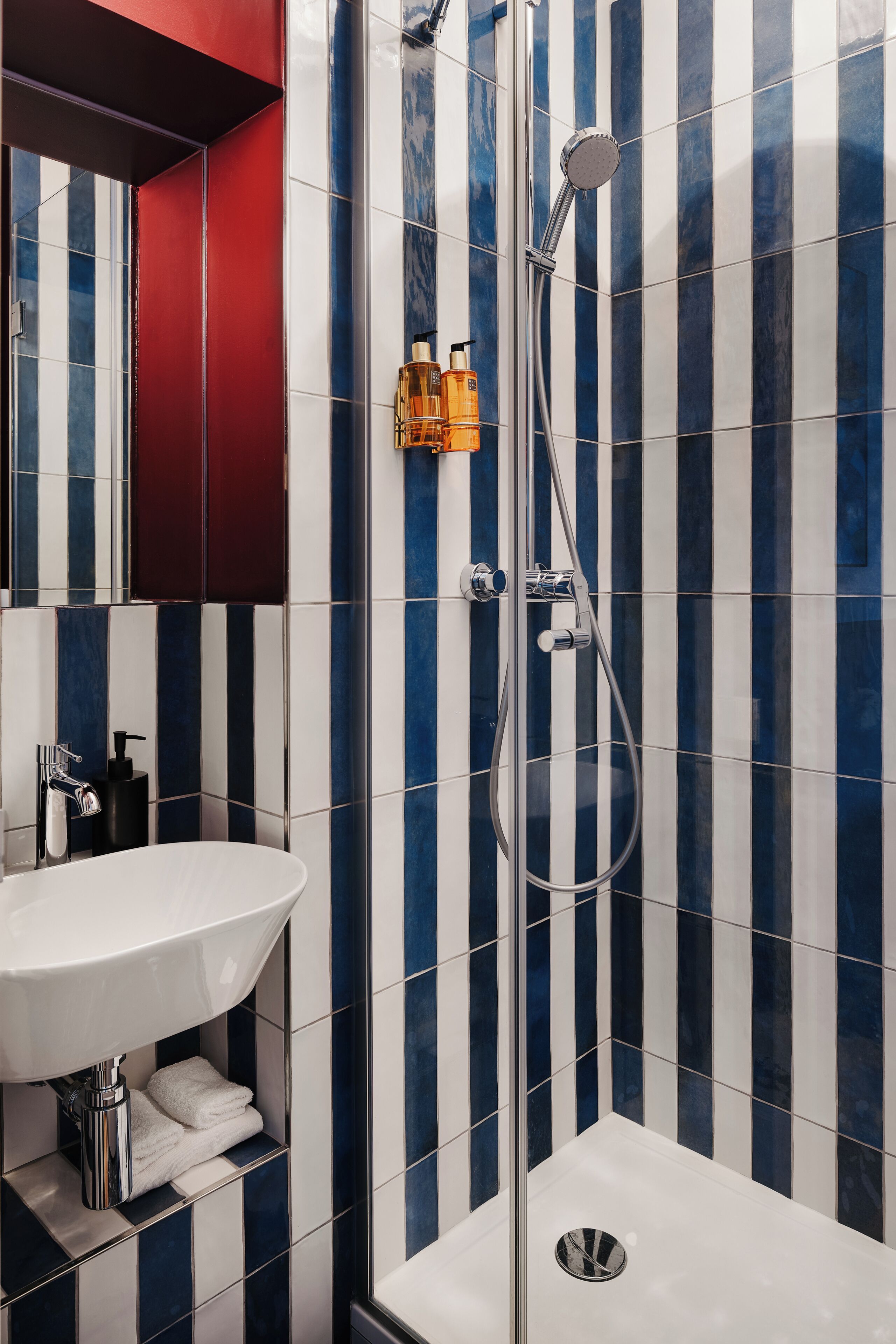 Une salle de bain avec une douche, un lavabo et un miroir.