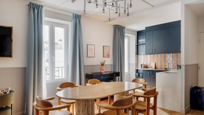 Een moderne keuken met een centraal eiland, houten stoelen en een eettafel.