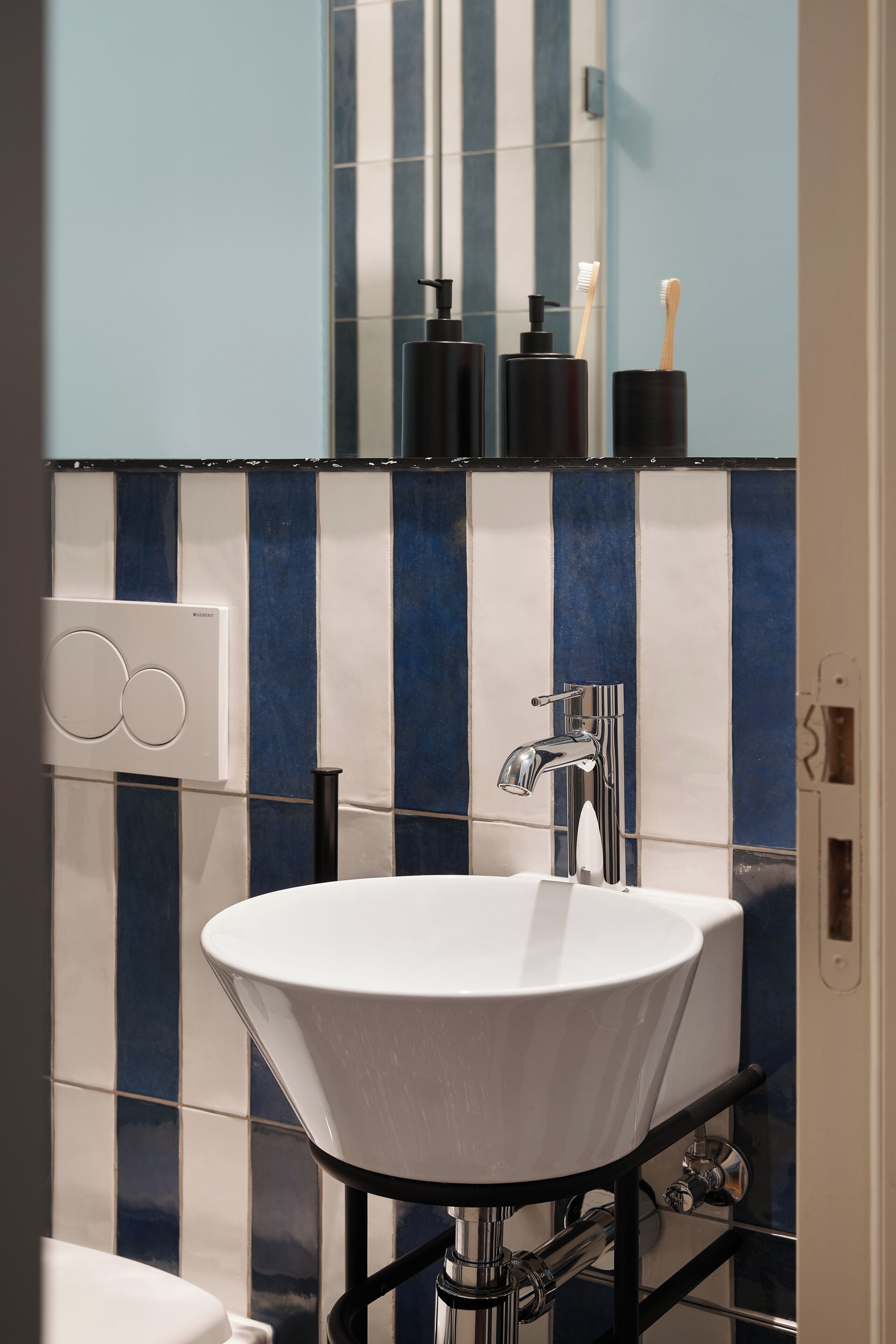 A bathroom with a white sink, chrome faucet, and a mirror above it.