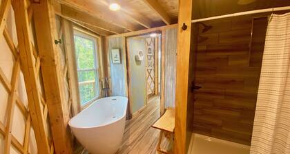 Elevated eclectic yurt with wrap-around porch, hot tub, and mountain view!