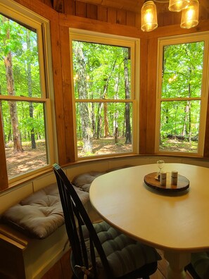 A room with a round table, bench seating, and large windows offering a forest view. - Private mountain cabin surrounded by Nat'l Forest! Visit wineries, hike the AT! (Cleveland)