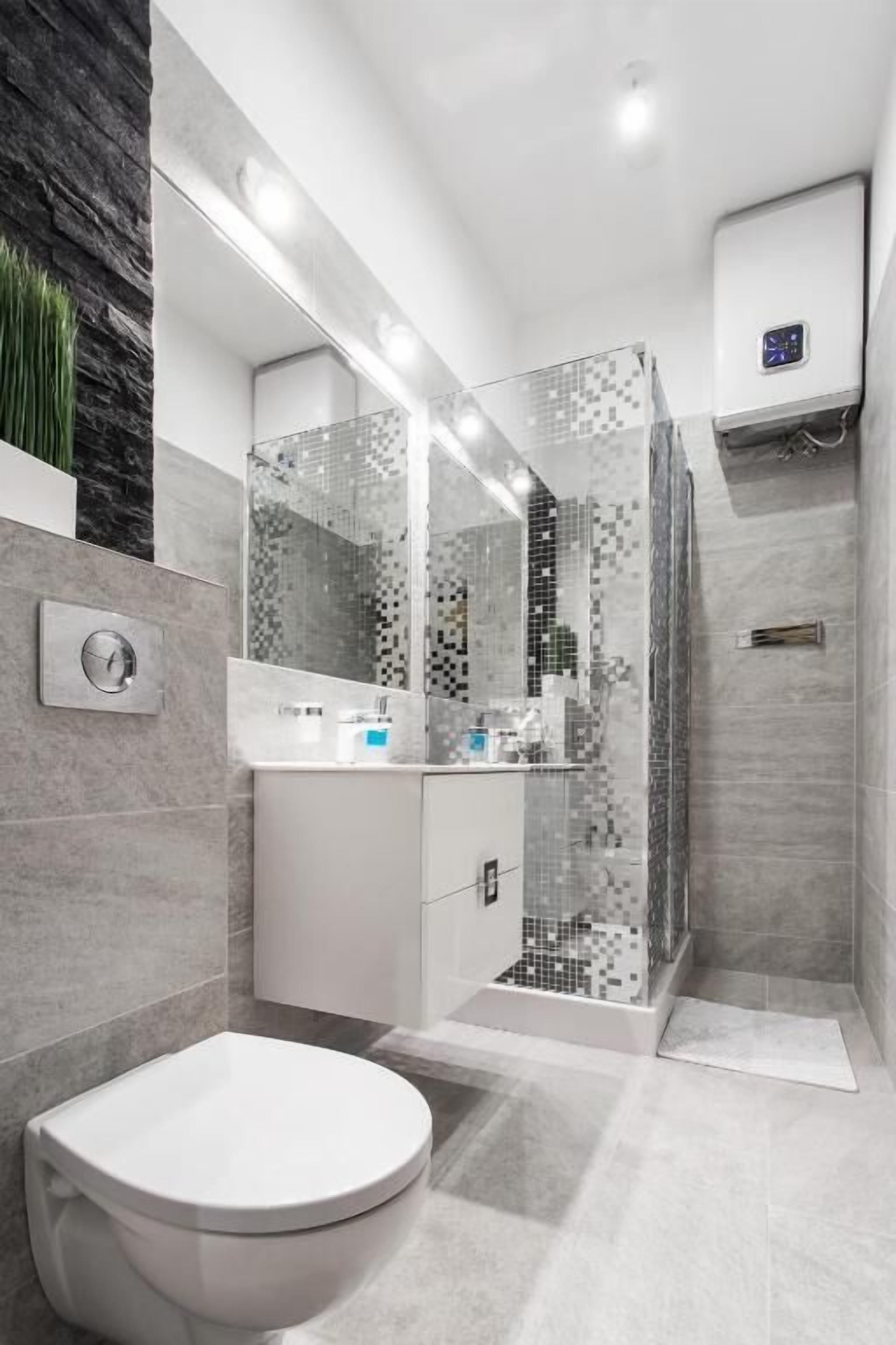 Een moderne badkamer met toilet, wastafel en douche.