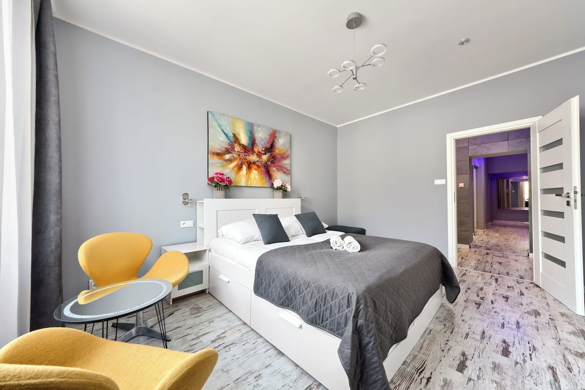 Ein modernes Hotelzimmer mit Bett, Schreibtisch, Stuhl und einem Bild an der Wand.