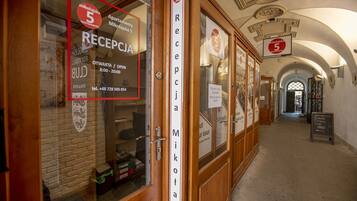 Zona de recepción con un cartel que indica la mesa de recepción, un número de teléfono y el horario de atención.