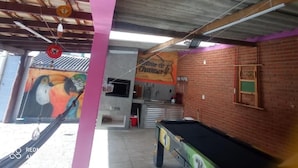 Een biljart in een ruimte met een muurschildering en een bakstenen muur.