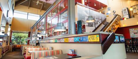 A diner with booths, a counter, and a staircase leading to an upper level.