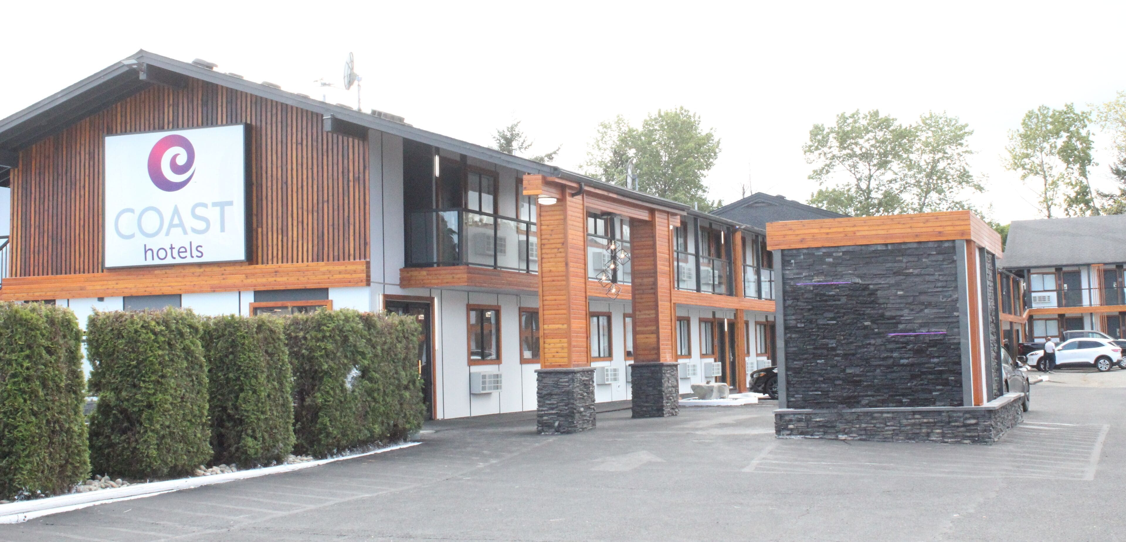 Un hôtel moderne avec une enseigne bien visible portant l’inscription « COAST hotels ».