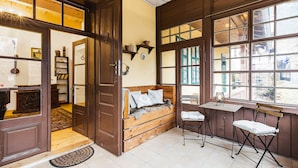 A cozy room with a wooden bench, a small table, and a window with a view. - Soví dom flat 2 (Svätý Anton)