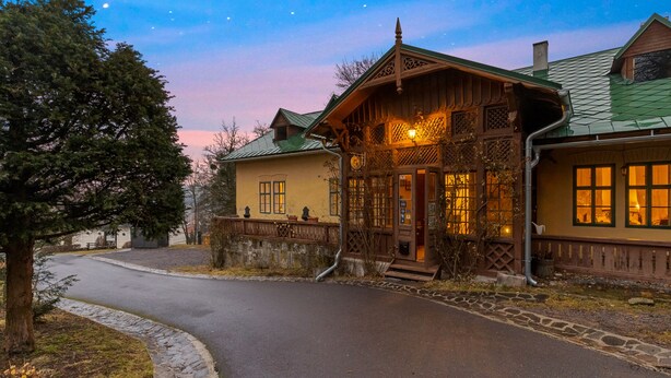 A traditional wooden building with a green roof, a stone pathway leading to the entrance, and a clear night sky. - Soví dom flat 2 (Svätý Anton)