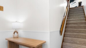 A staircase with wooden handrails and carpeted steps. - Cozy Dog-Friendly Cottage · Steps to Gulf Beach (Port St. Joe)